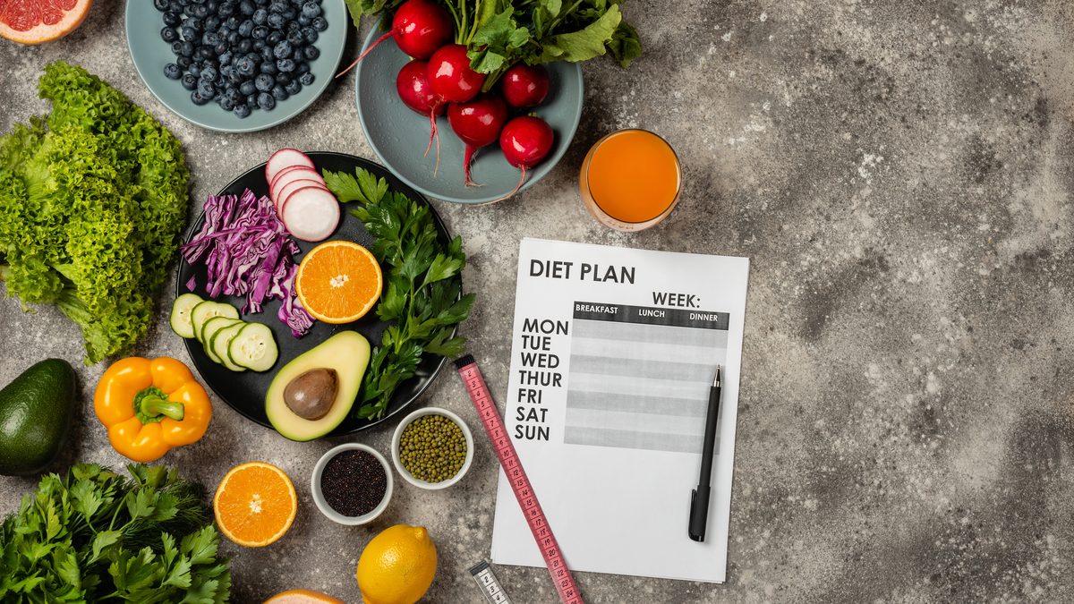 Platoul de slăbire: de ce se oprește cântarul și ce faci concret 1 O fișă de plan alimentar și un centimetru de croitorie, înconjurate de legume, fructe de pădure și avocado