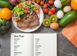 Un plan alimentar săptămânal scris într-un carnet, înconjurat de legume, fructe, ouă, somon și o farfurie cu salată